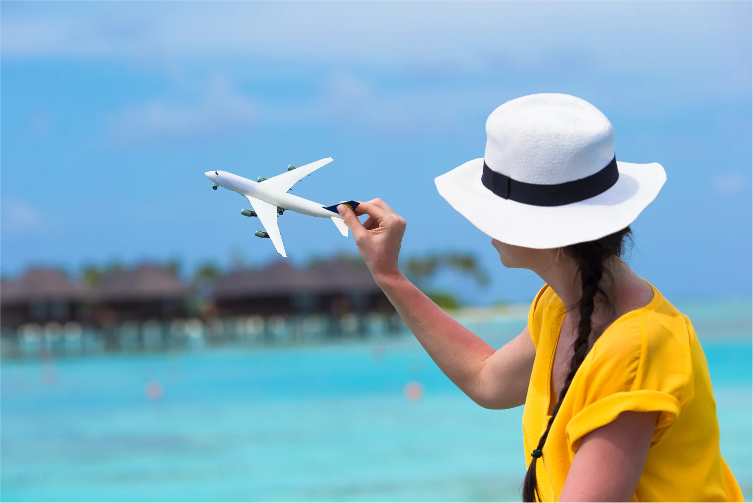 lady-holding-toyplane-near-sea