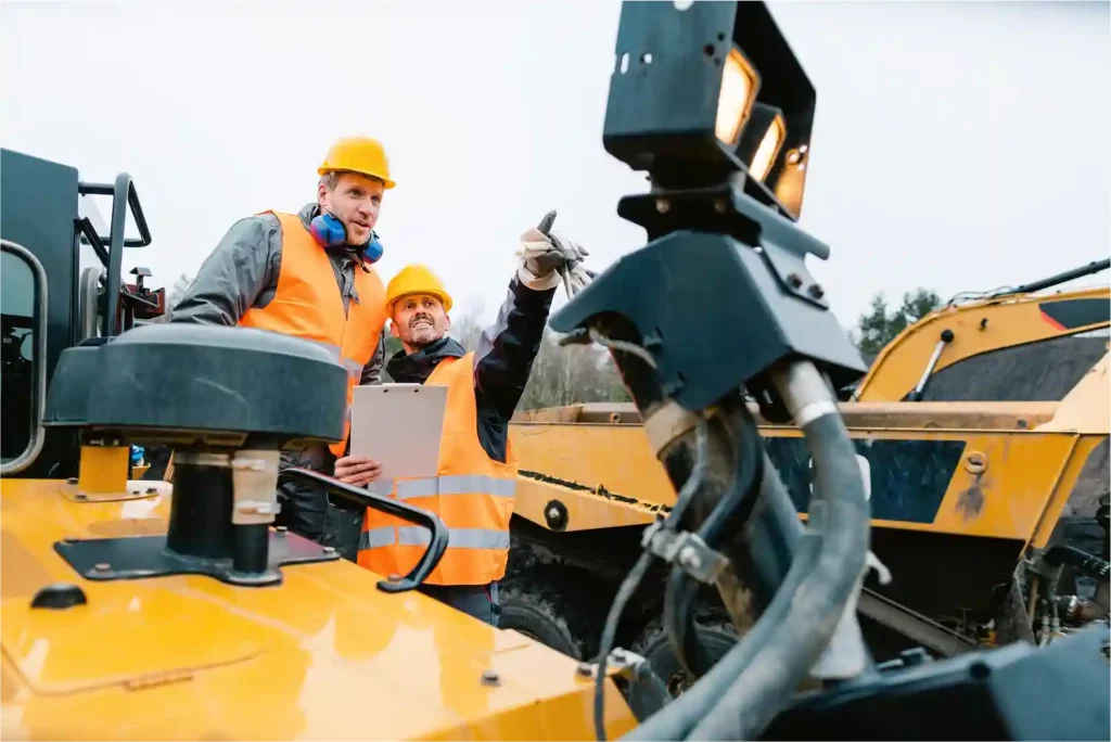 engineers-discussing-about-yellow-heavy-vehicle
